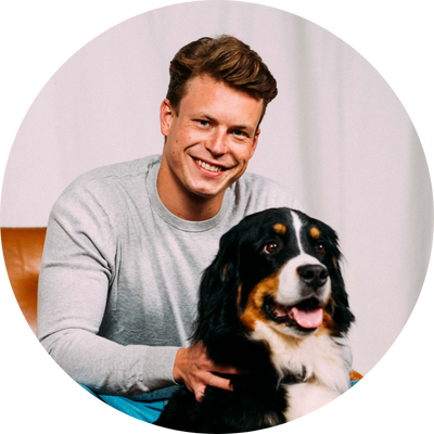 Tierarzt Volker Wilke mit Hund Tierarzt Volker Wilke mit grauem Pullover, davor schwarz-weißer Hund