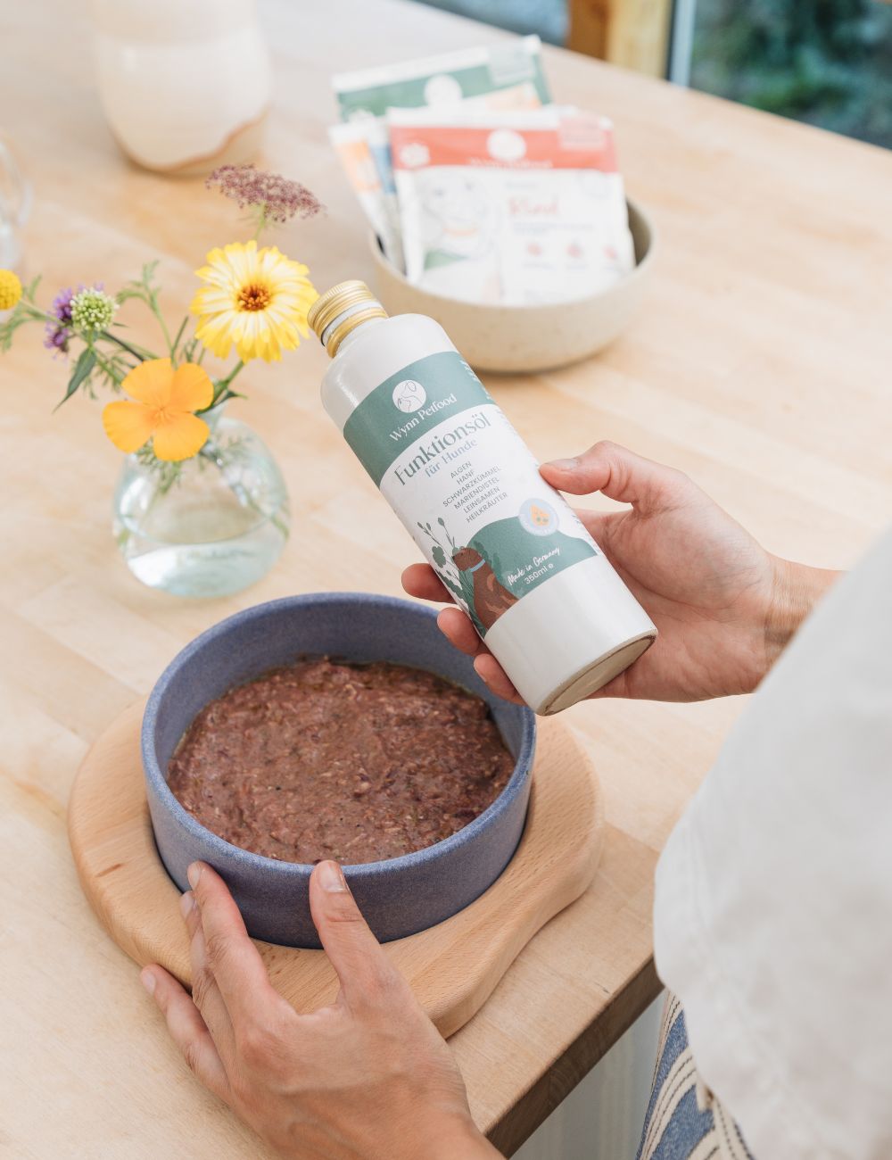 Wasser aus einem Krug, das in einen Napf geleert wird.